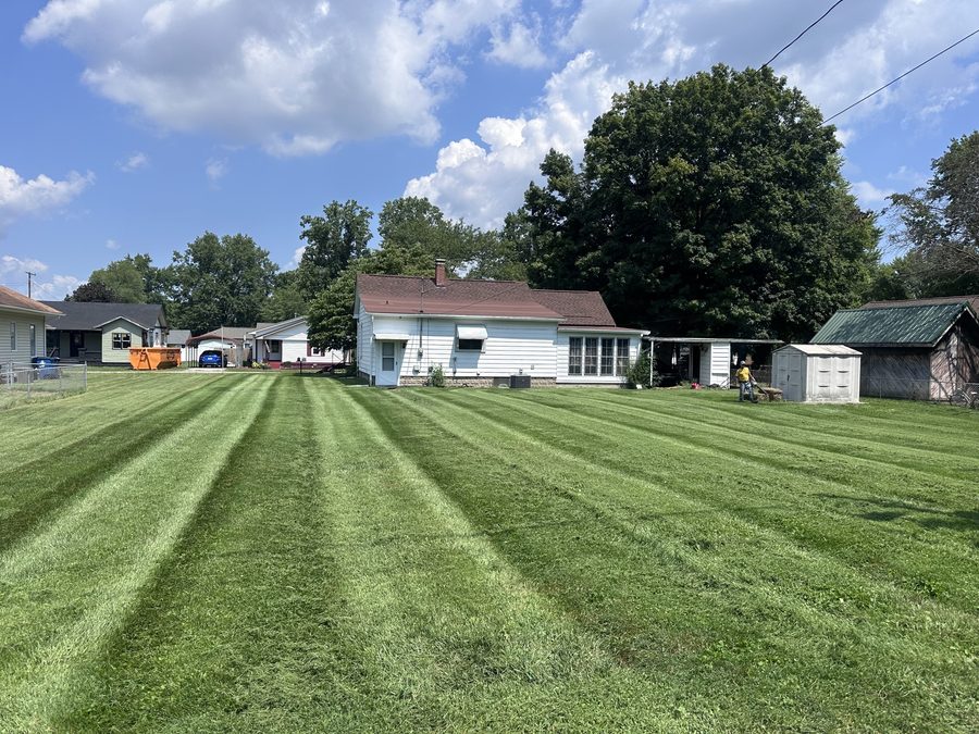 Wide property mowing with professional stripe pattern