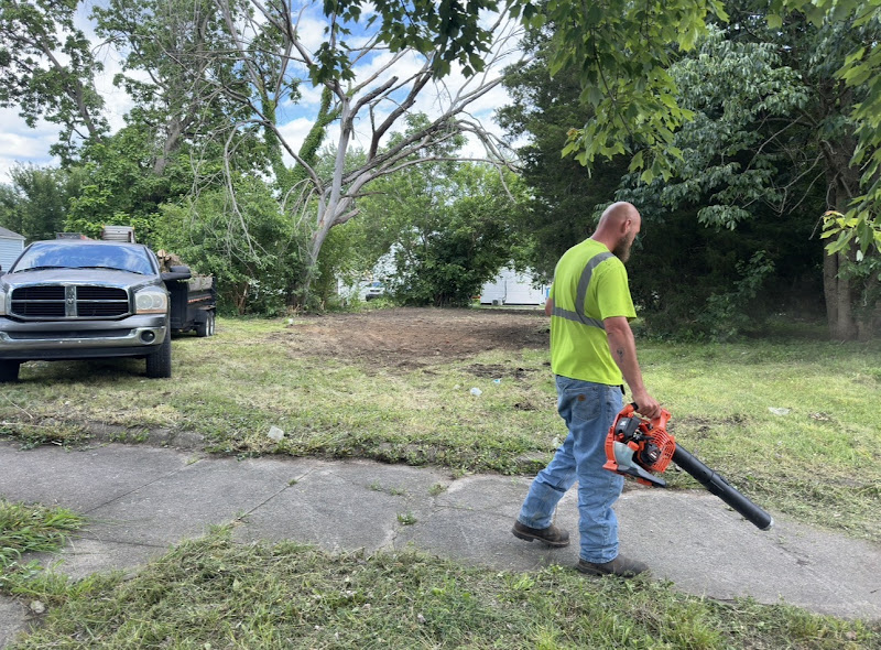 Matt Tusing owner of Tees Lawn Service blowing off driveway after mowing in Terre Haute Indiana